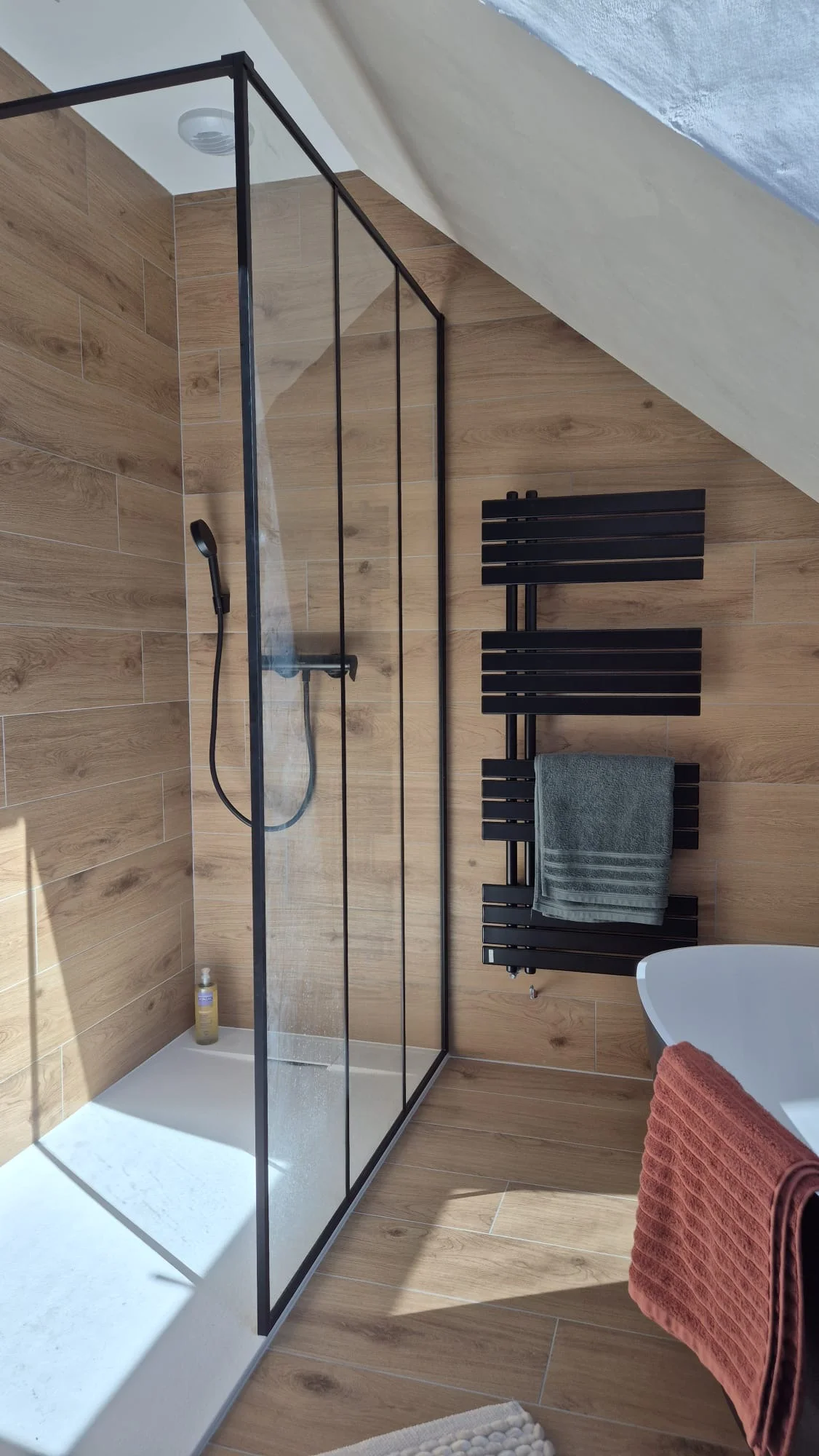 Mornant — Douche à l'italienne avec paroi verrière noire et carrelage effet bois